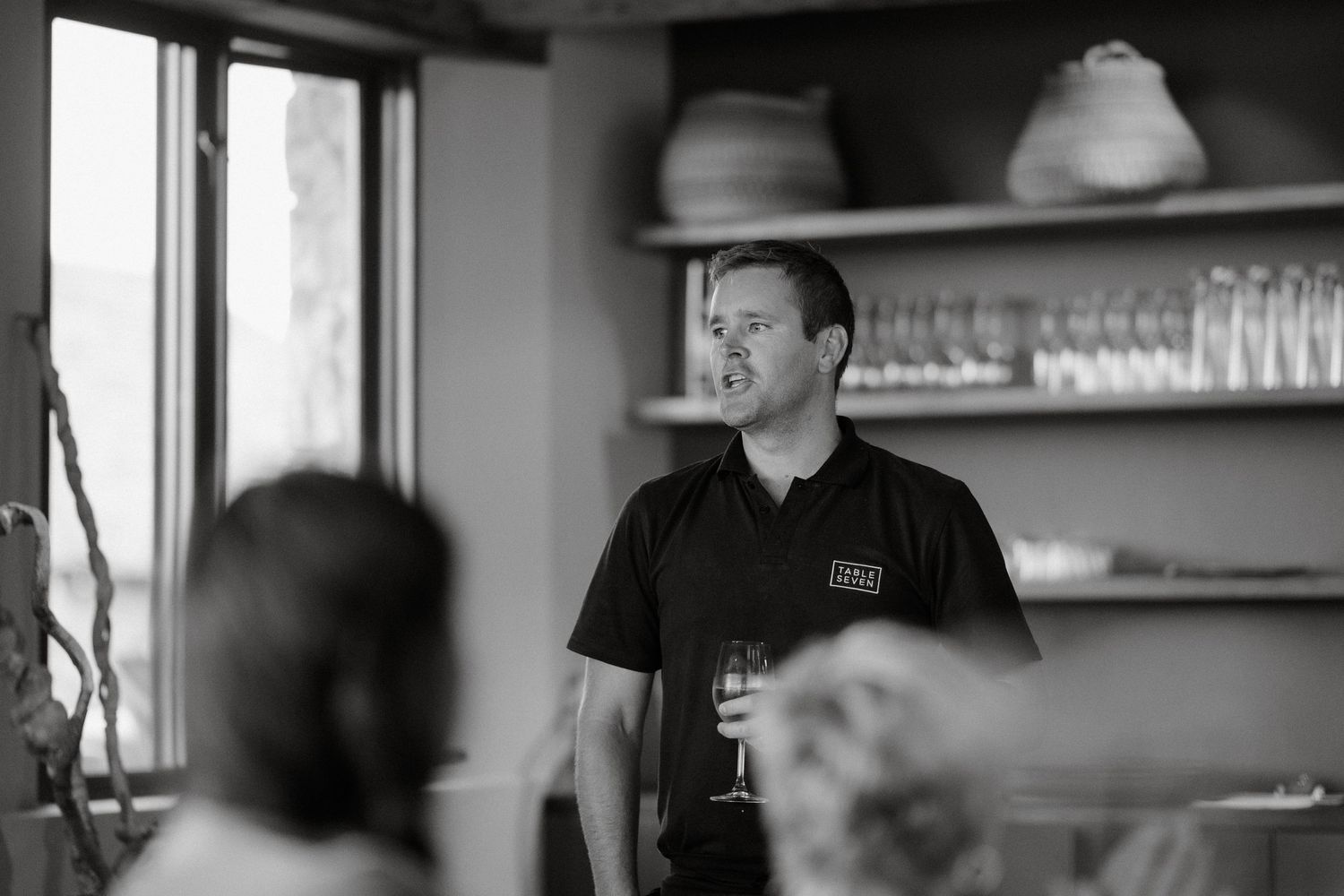 A casual indoor gathering with staff and guests interacting in a restaurant setting.
