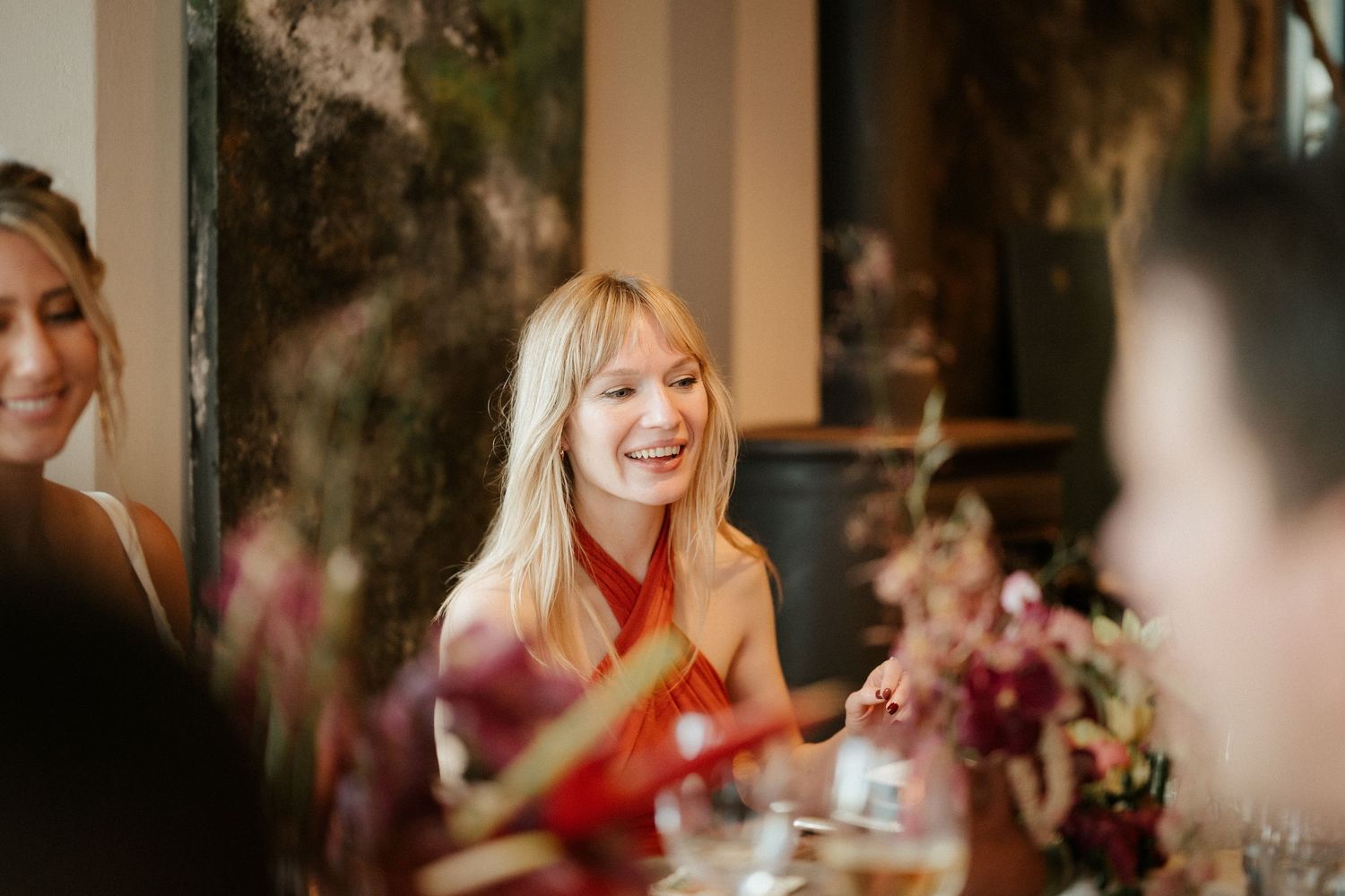 Guests enjoying a celebratory dinner with warm lighting and festive atmosphere.