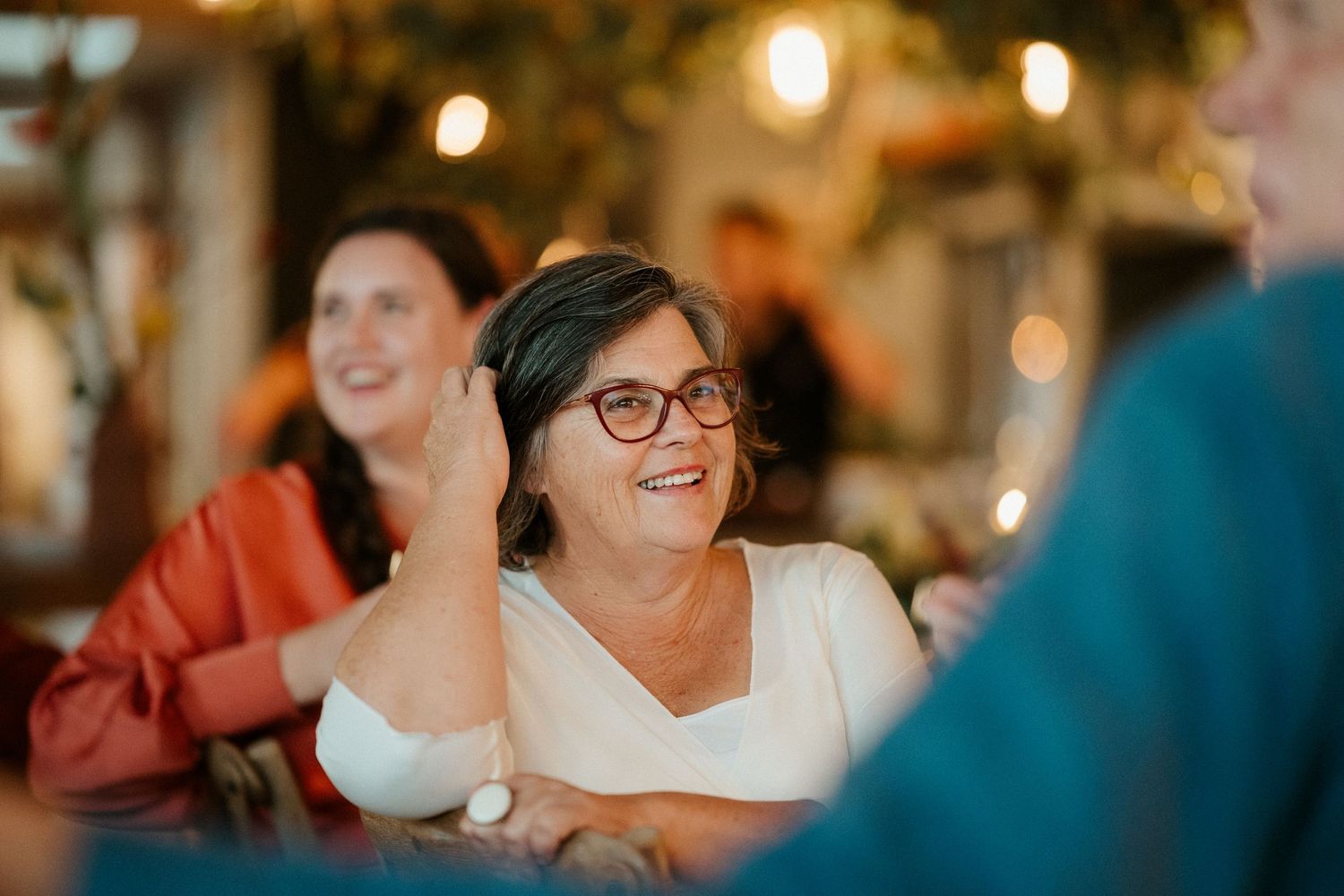 Warm candid moment of dinner guests sharing laughter around a table.