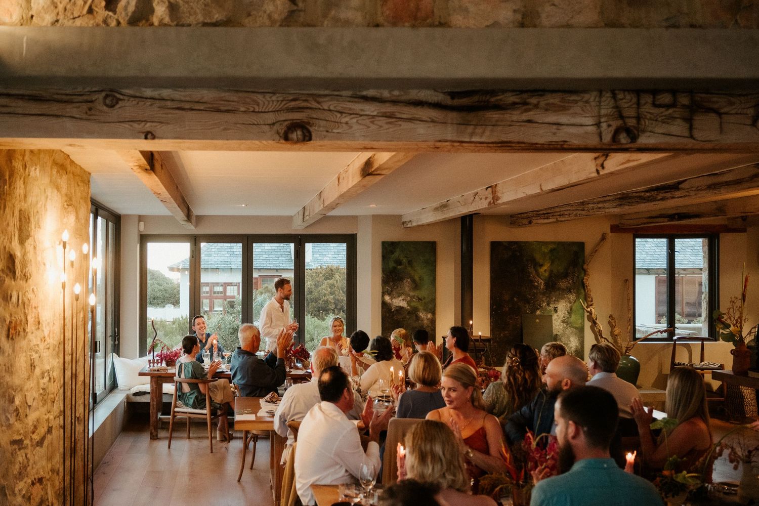 Rustic wedding reception venue with exposed stone walls and large windows letting in natural light.