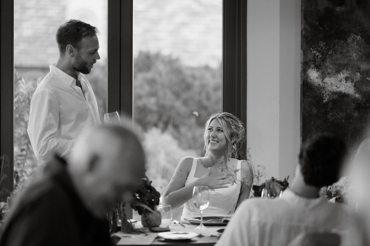 A black and white capture of a wedding reception speech moment.
