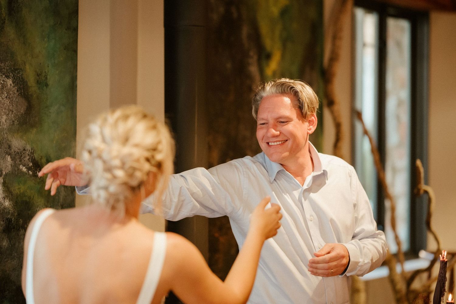 Wedding celebration with dancing and laughter at an elegant indoor venue.