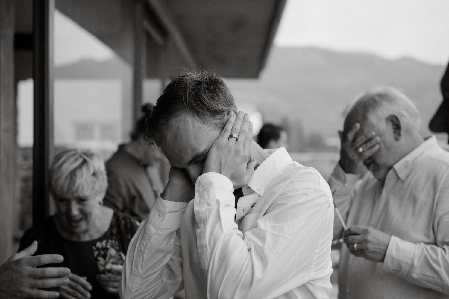 Black and white candid photograph of emotional reactions during a special event.