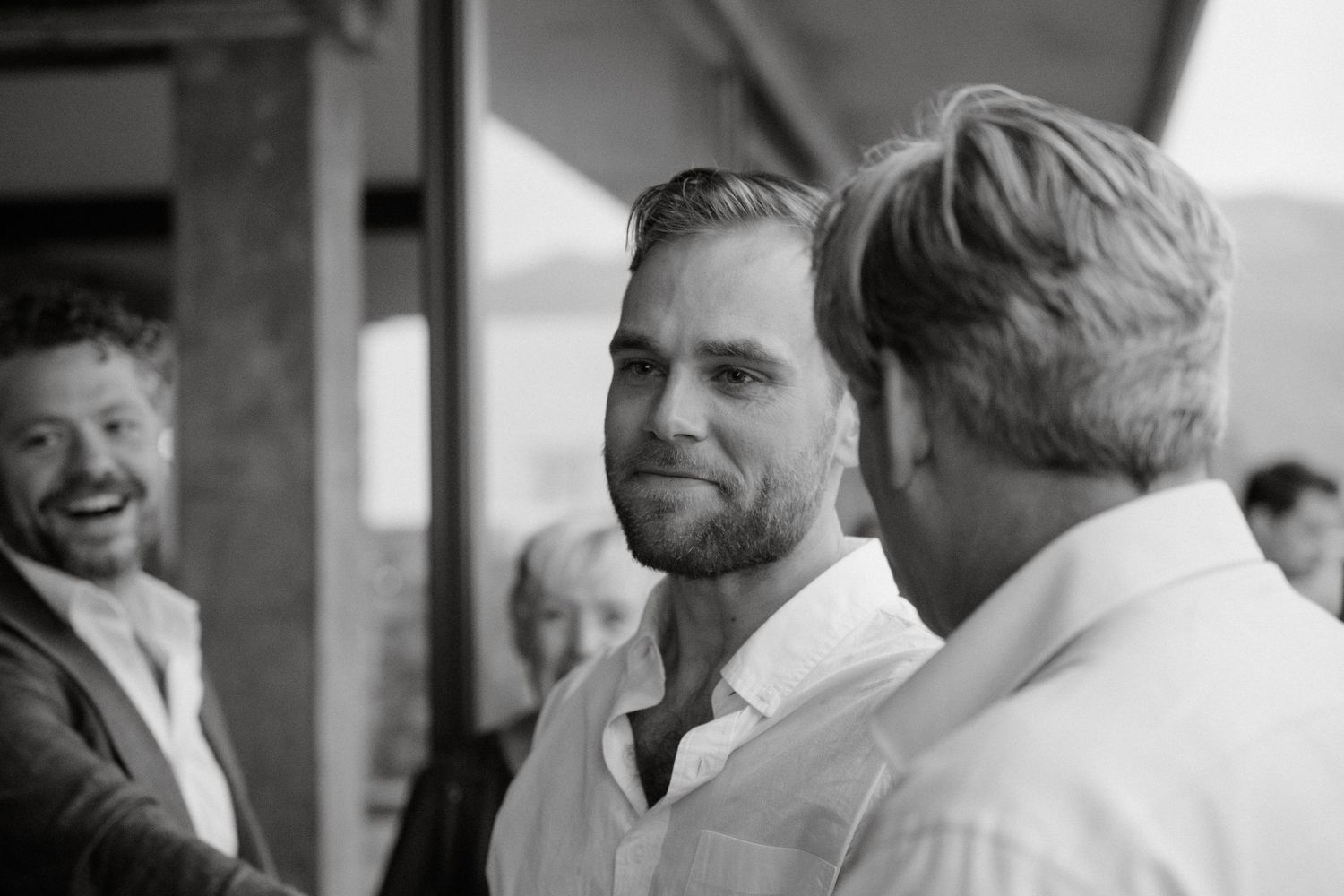 Three people sharing laughs during a black and white candid moment.