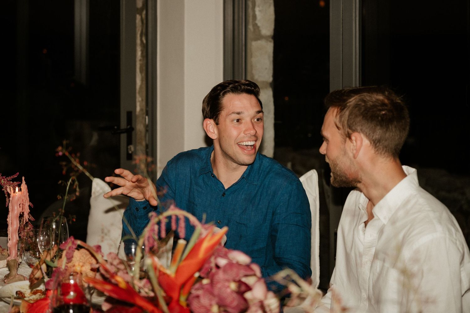 Animated conversation between dinner guests at an elegantly decorated table.