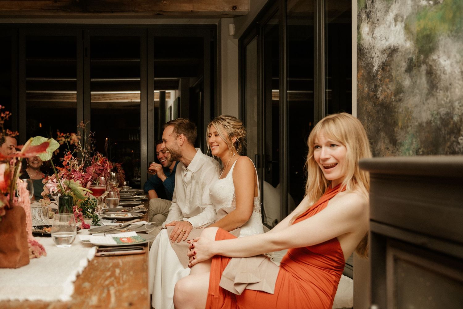 Guests seated at an elegantly decorated dinner table with floral centerpieces.