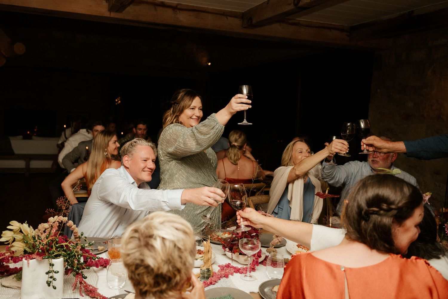 Wedding guests raise their glasses in a celebratory toast during the reception dinner.