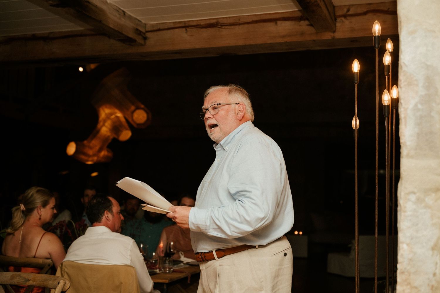 Speaker delivering a heartfelt toast at an intimate wedding reception.