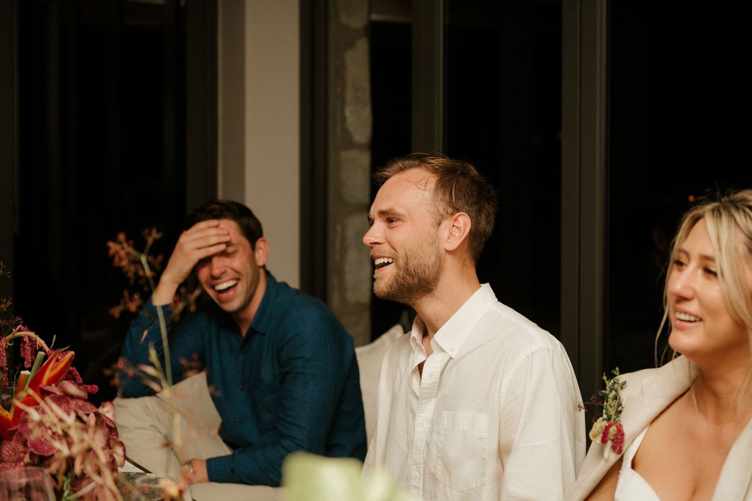 Wedding guests share laughter and joy during a reception dinner.