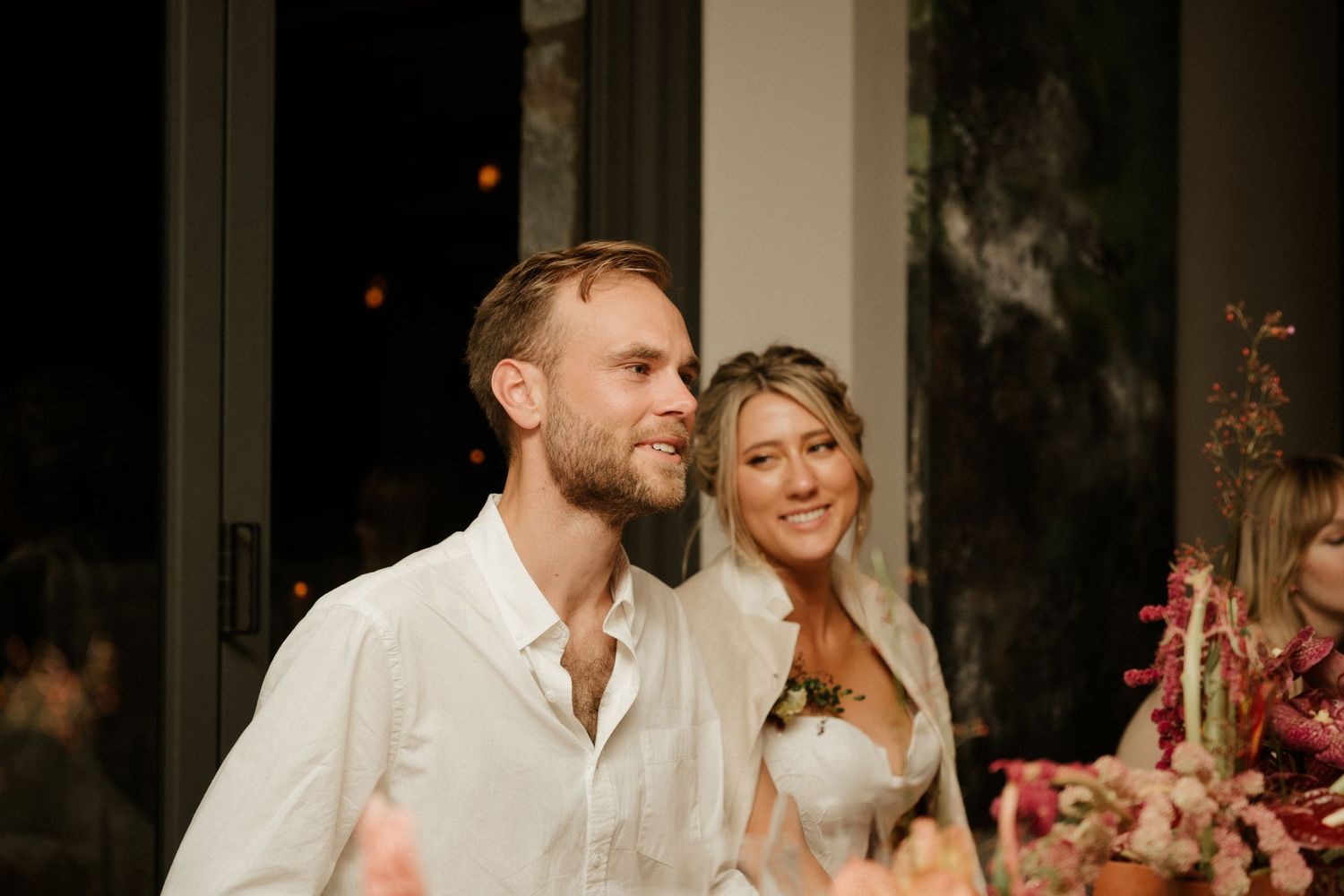 A couple shares an intimate moment during their wedding reception dinner.