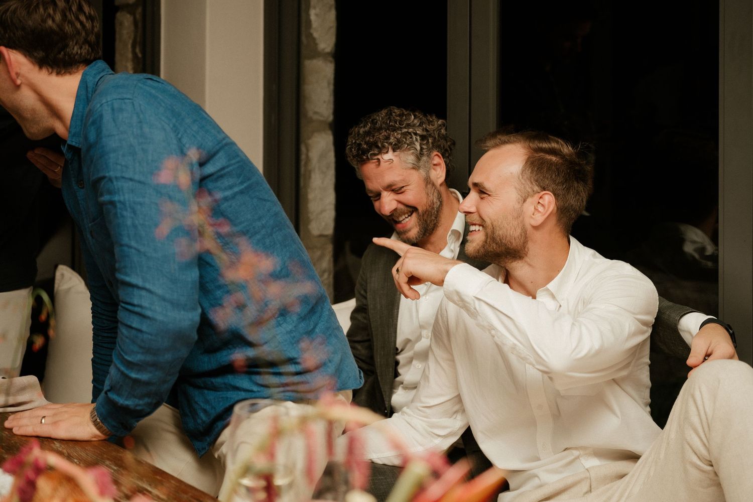 Guests share a lighthearted moment during a dinner gathering.