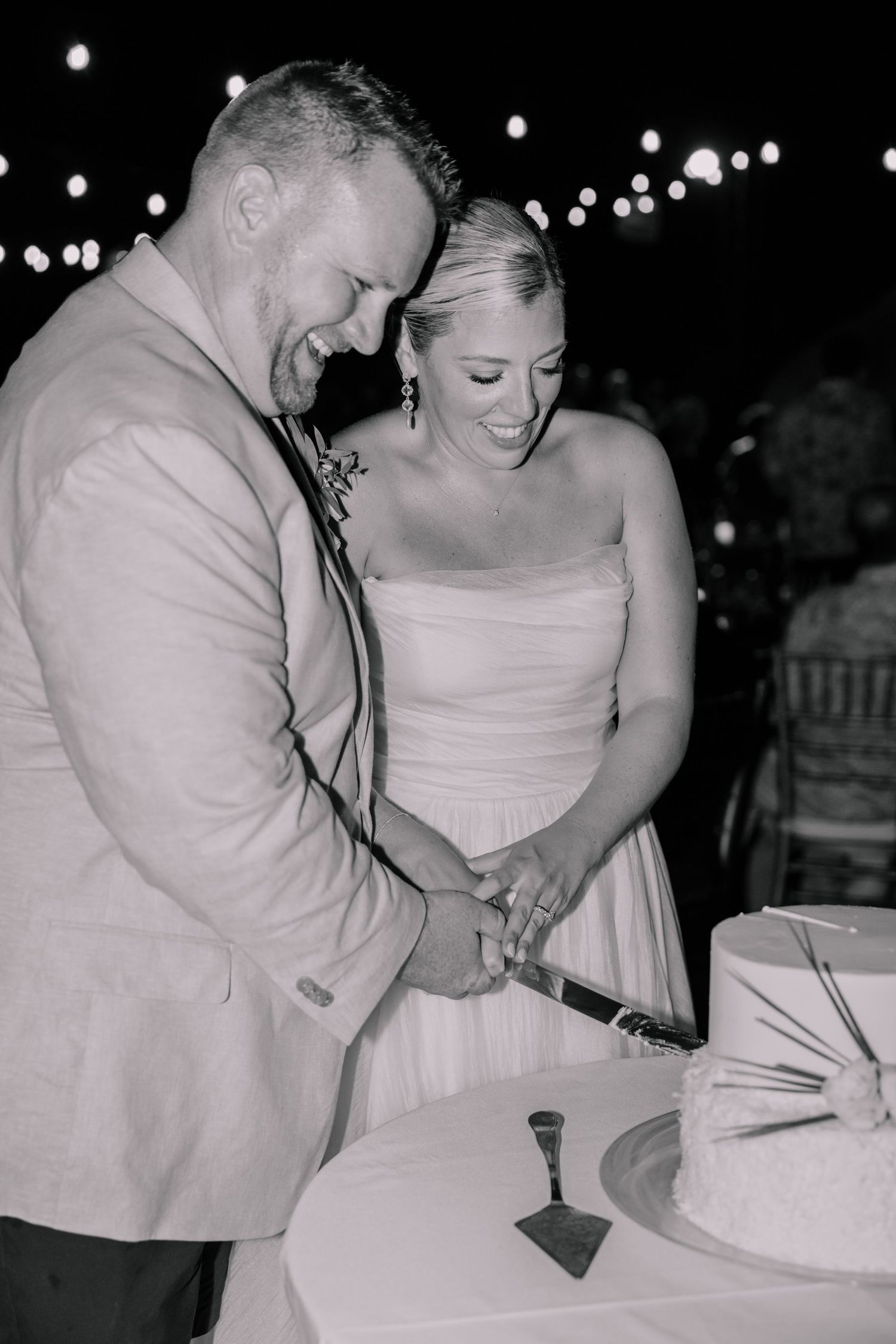 Black and white photo of couple signing wedding documents at reception.