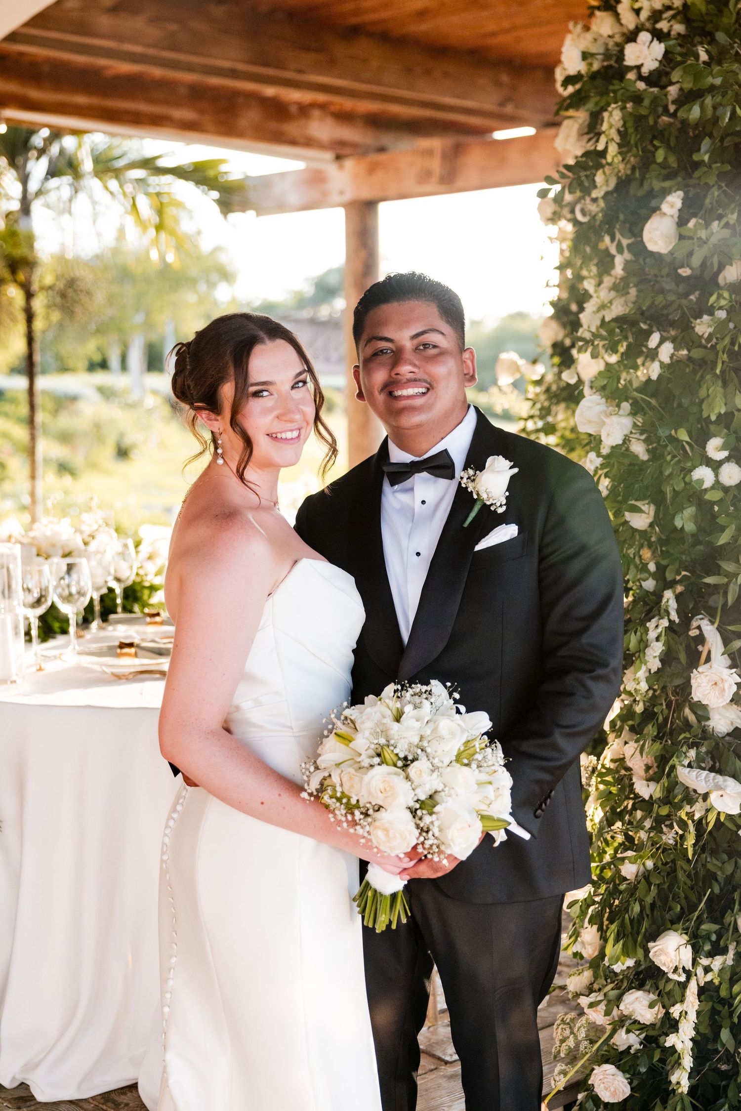 Wedding couple embracing on a stone wall overlooking a serene lake. Casa de Campo