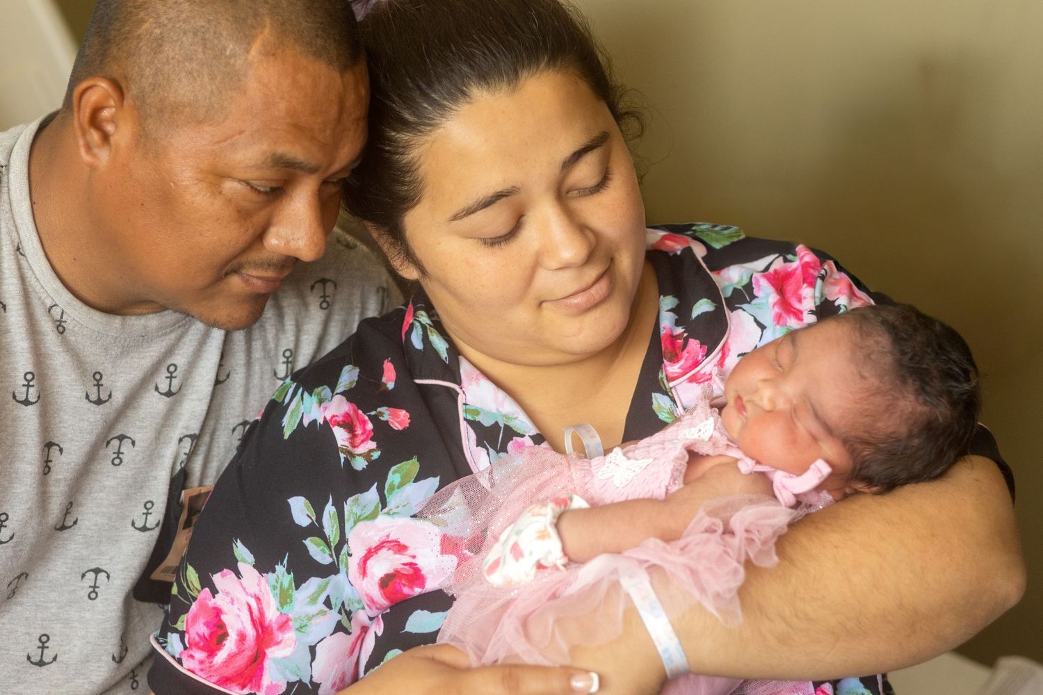 A tender moment showing a parent cradling and bonding with their newborn baby in a hospital room.