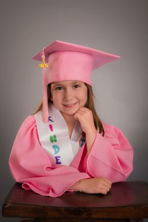A series of four photos showing a graduate in a pink cap and gown posing on a wooden bench against a gray background.