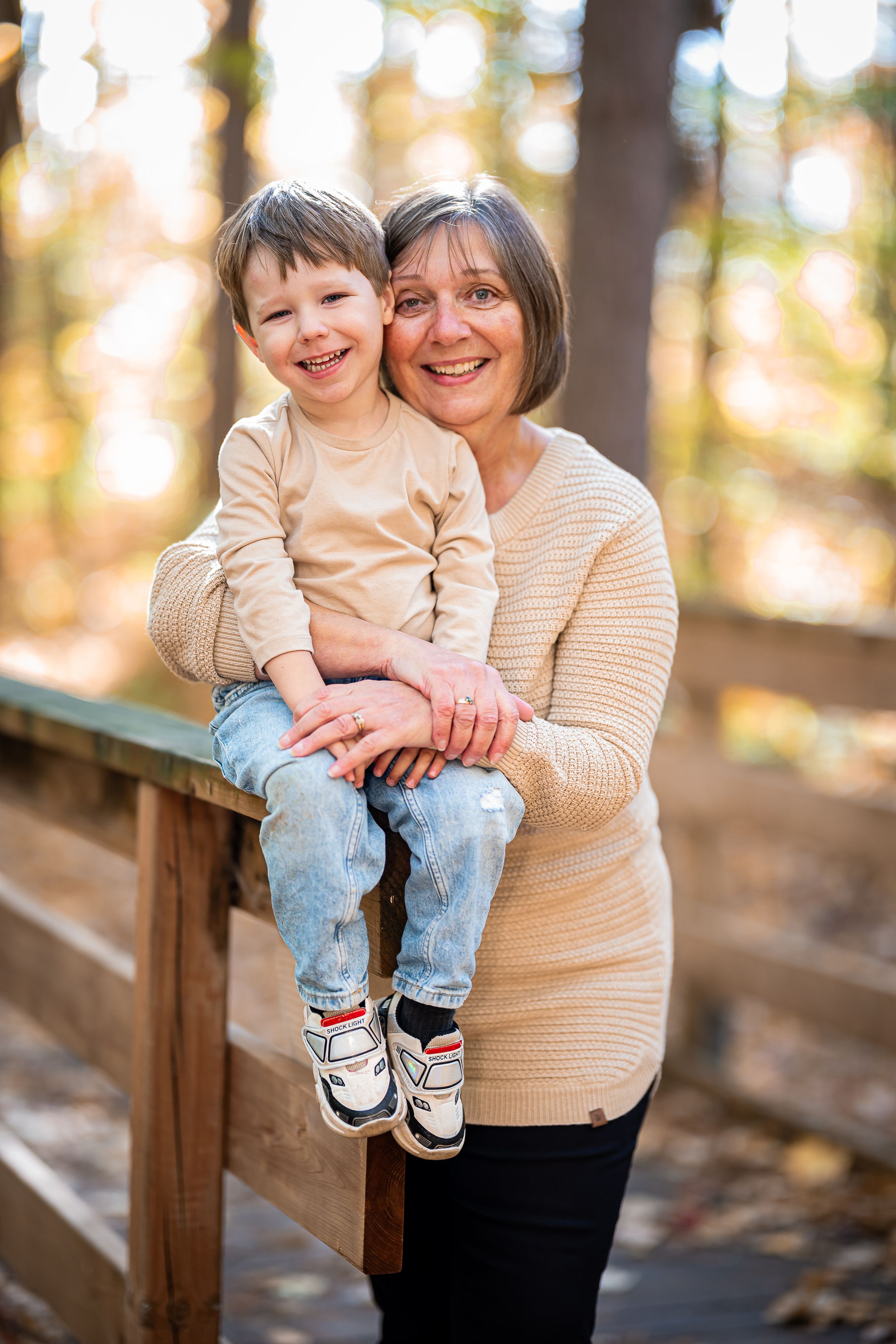 A heartwarming moment shared between a child and adult sitting on a wooden railing outdoors in autumn.