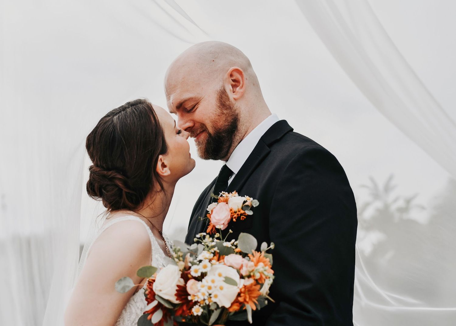 a romantic kiss beneath the veil