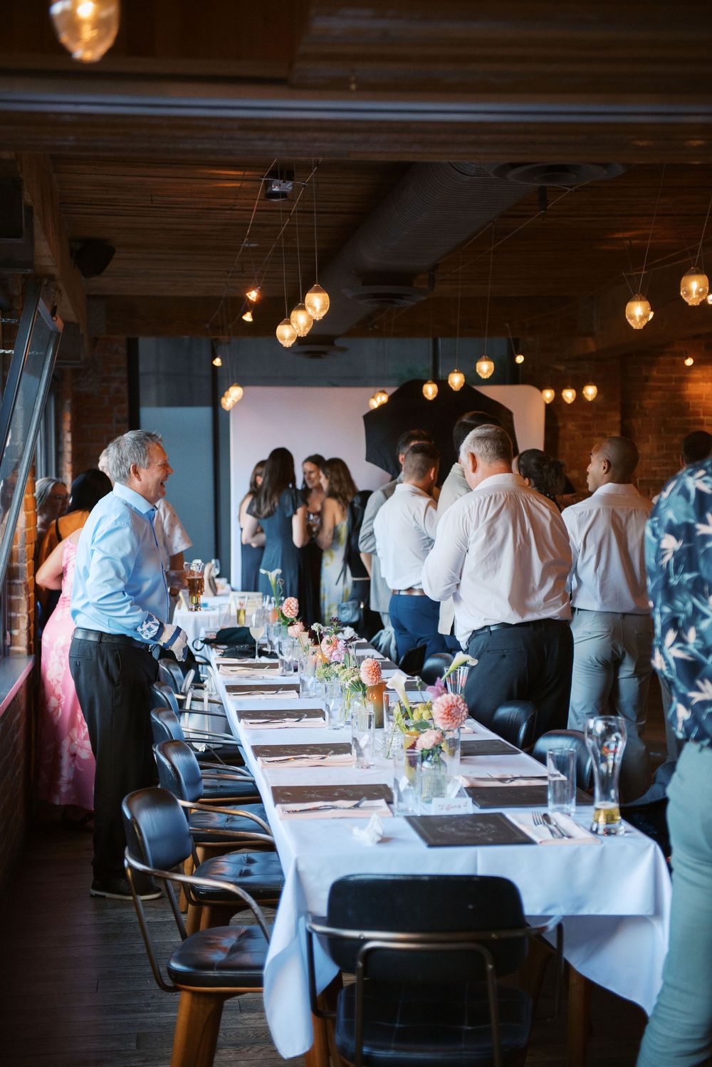 An elegant restaurant dining room setup with white tablecloths and ambient lighting for a special event.