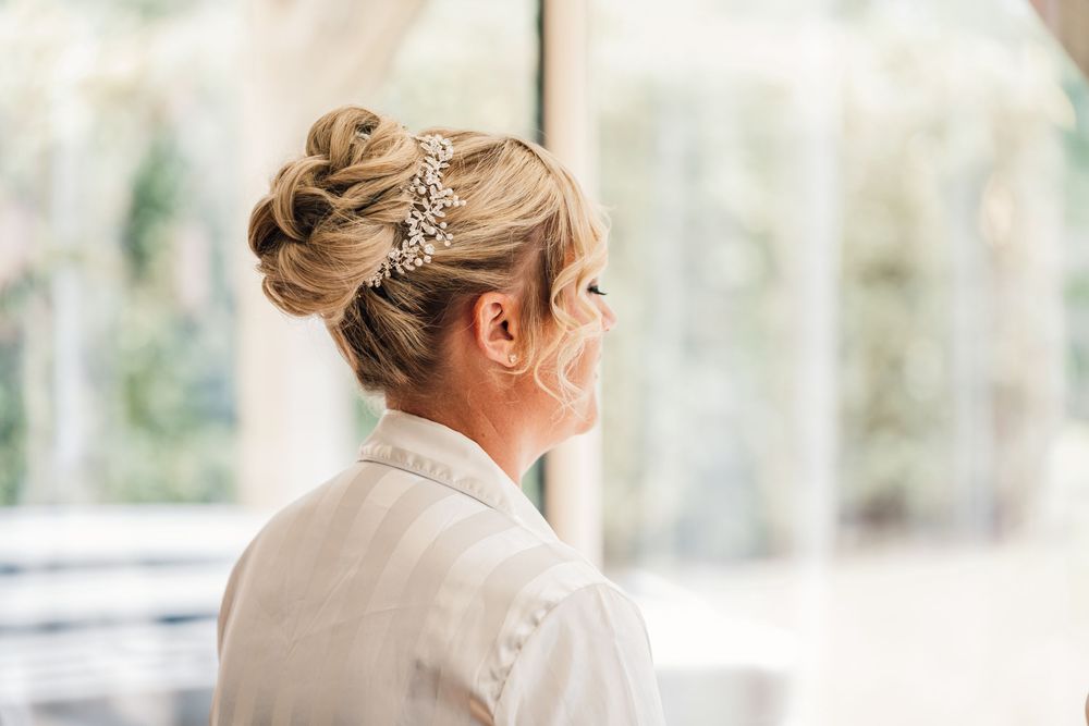 Elegant hairstyle with sparkly hair accessories captured in soft natural light.