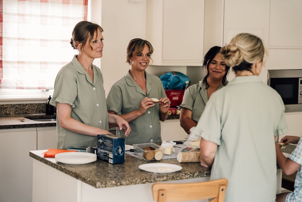 Group gathering in a bright kitchen with casual conversation and laughter.
