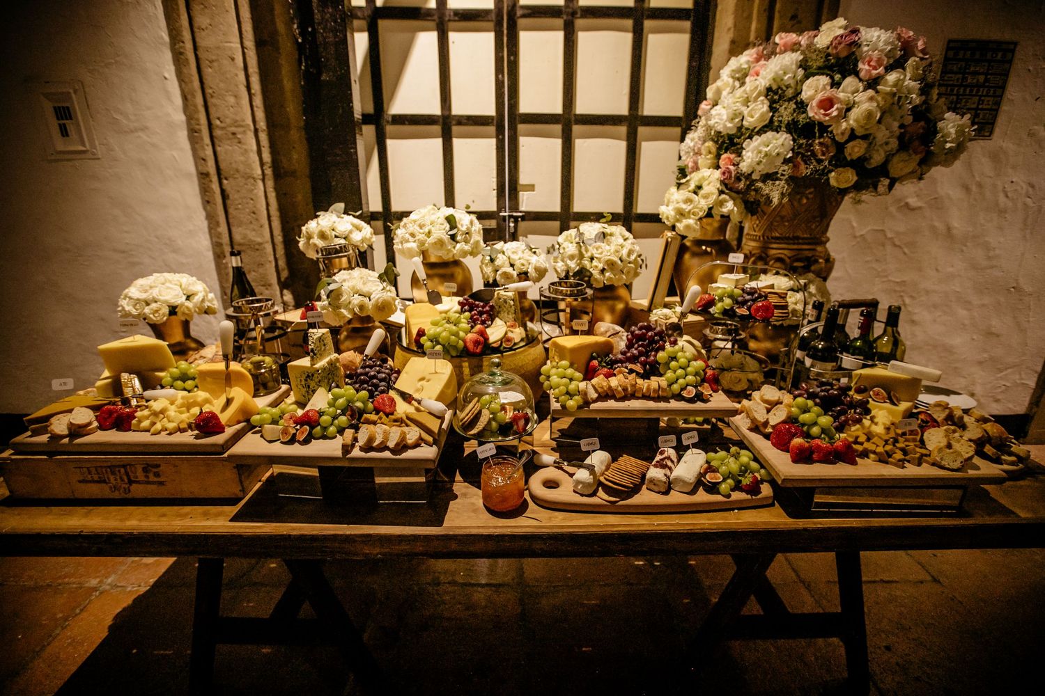 Luxurious wedding reception buffet table with elegant floral arrangements and gourmet food displays.