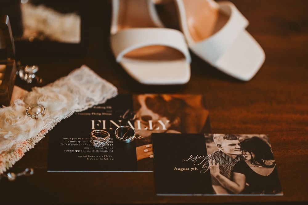 Artistic wedding photography details arranged on a dark wooden surface with dramatic lighting.