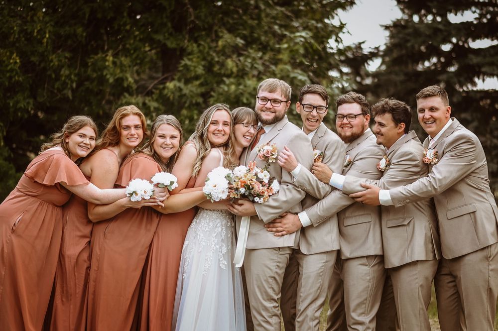 Wedding party poses together in a series of candid group shots wearing tan and rust colored attire.