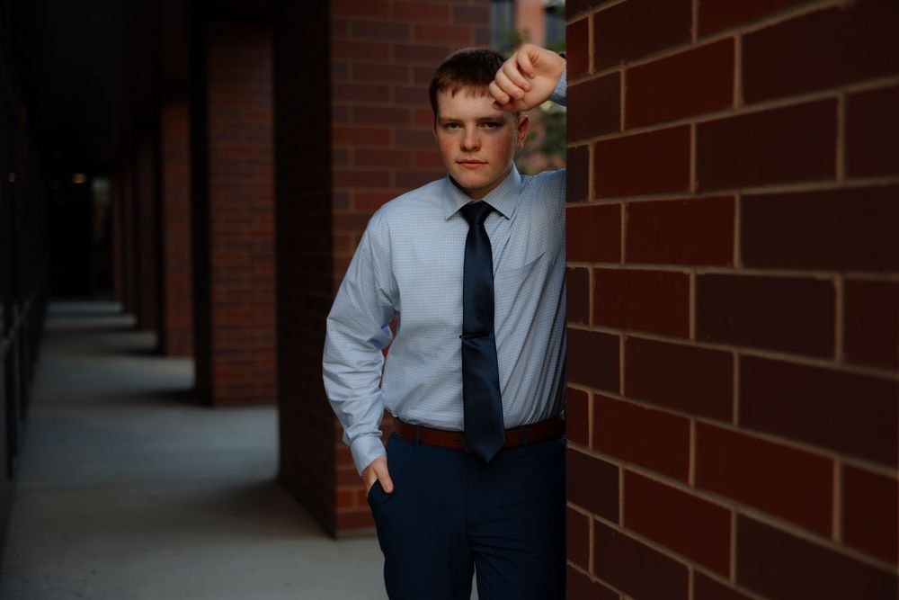 Professional portrait session against a brick wall background showing different poses in business attire.