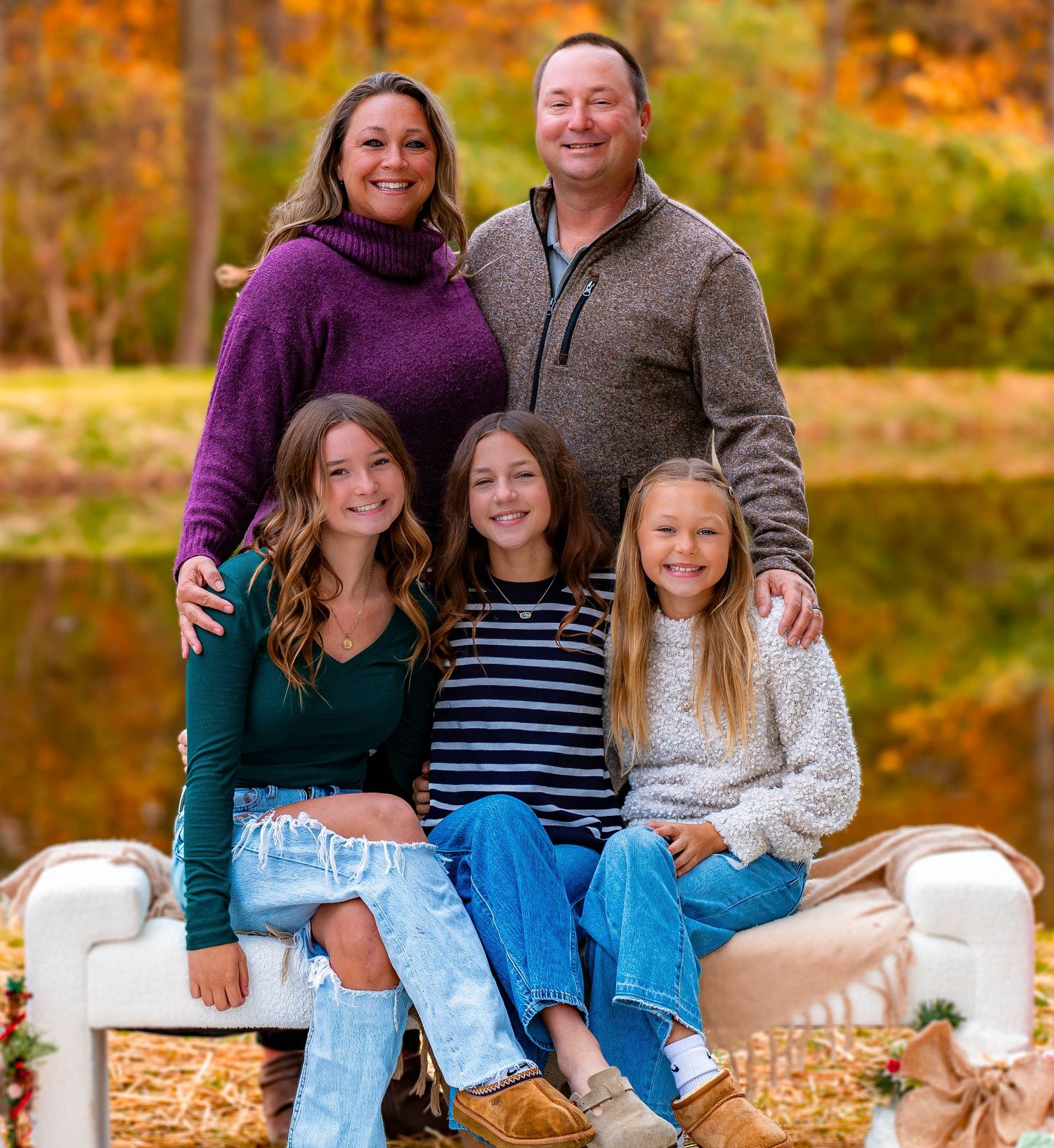 Holiday family photo session with Christmas decorations and rustic wooden backdrop.