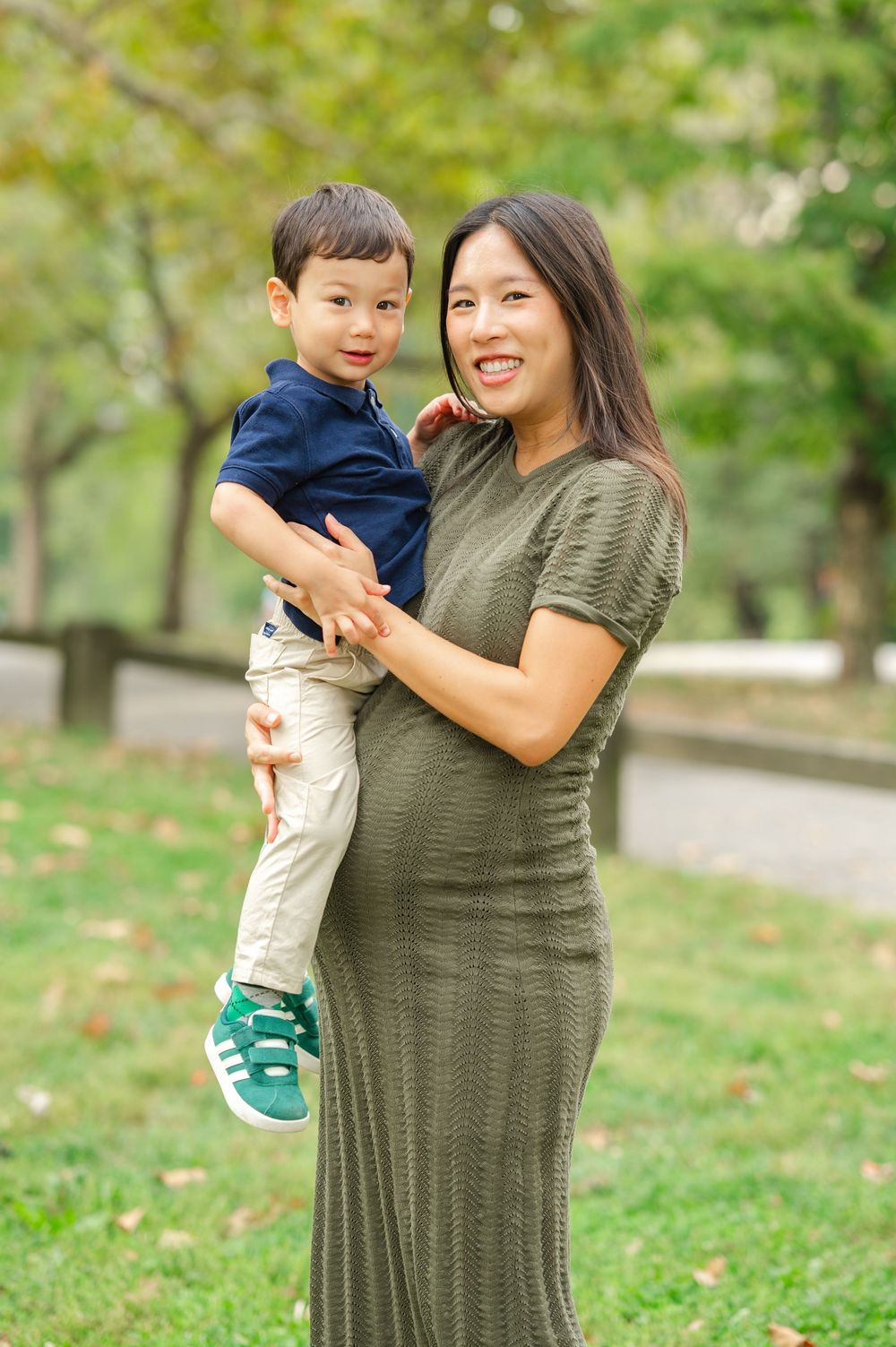 A mother and child share a joyful moment together outdoors in Central Park on a sunny day.