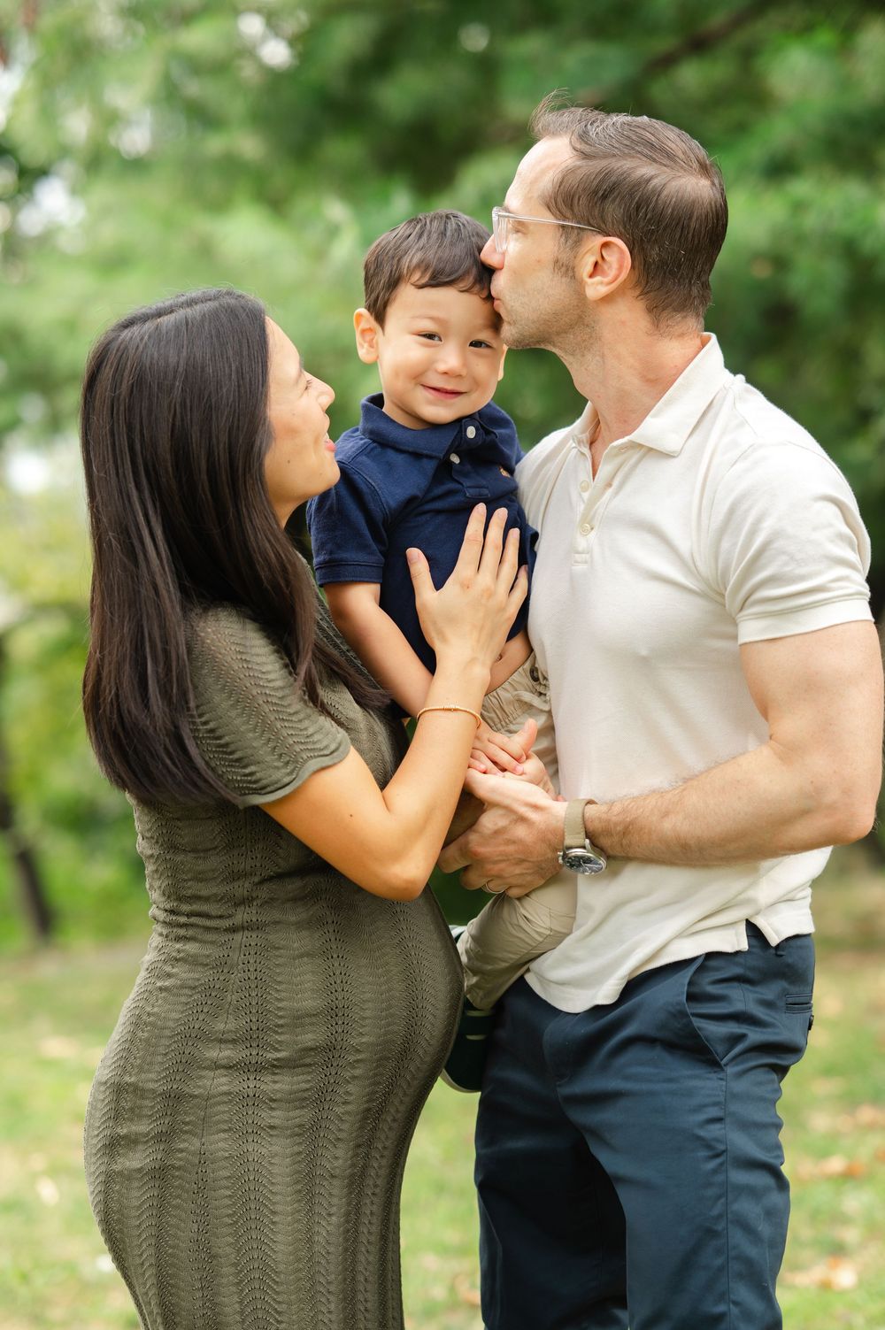 Candid moments of a family laughing and playing together in Central Park during a fall family photoshoot.