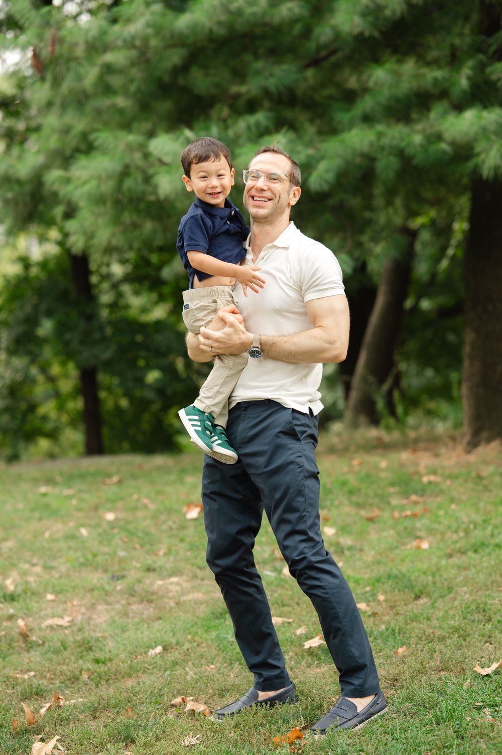 Playful family interaction captured in a series of candid moments against a wooded backdrop.