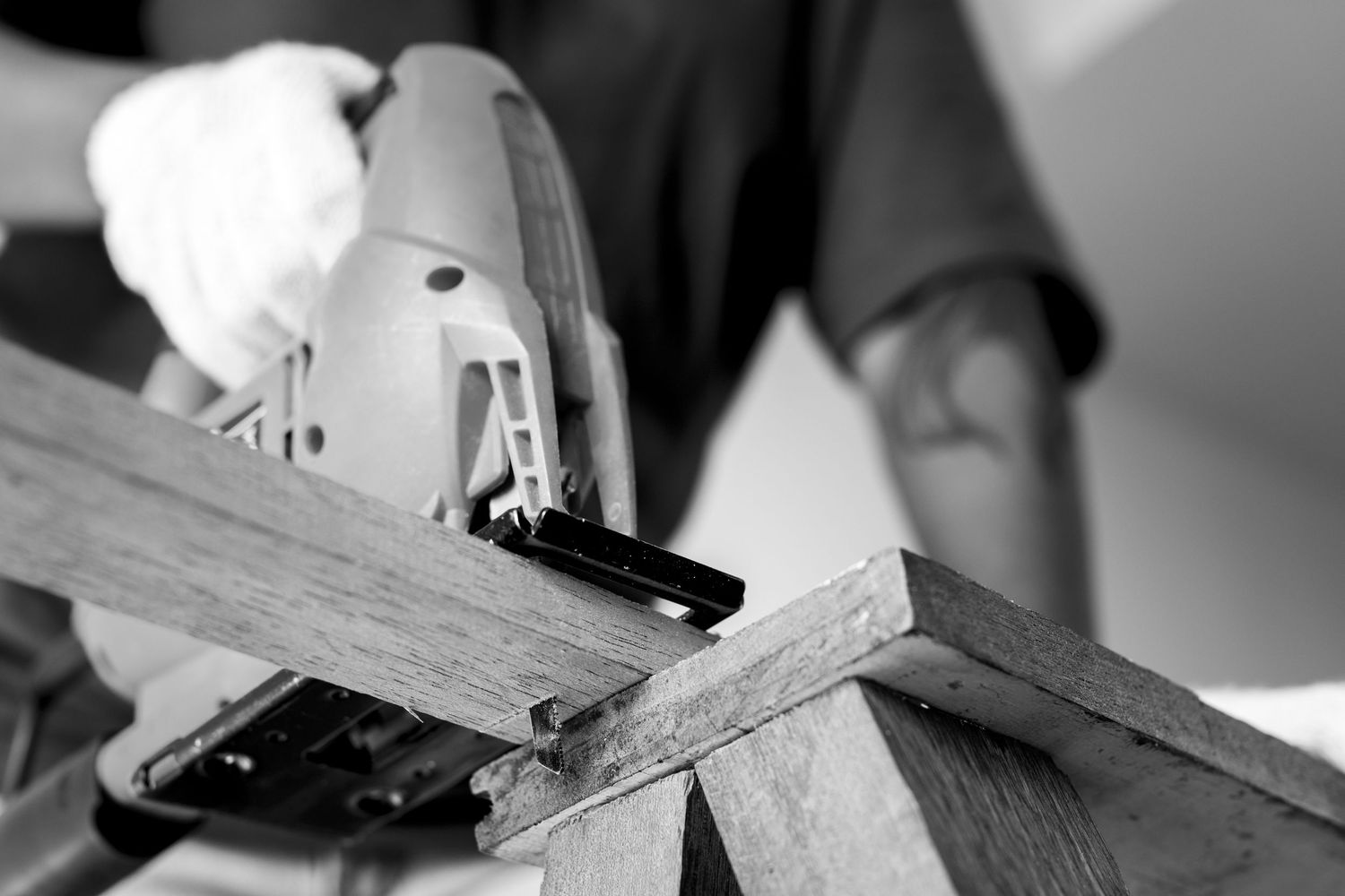 Close-up black and white shot of a power tool cutting through wood.