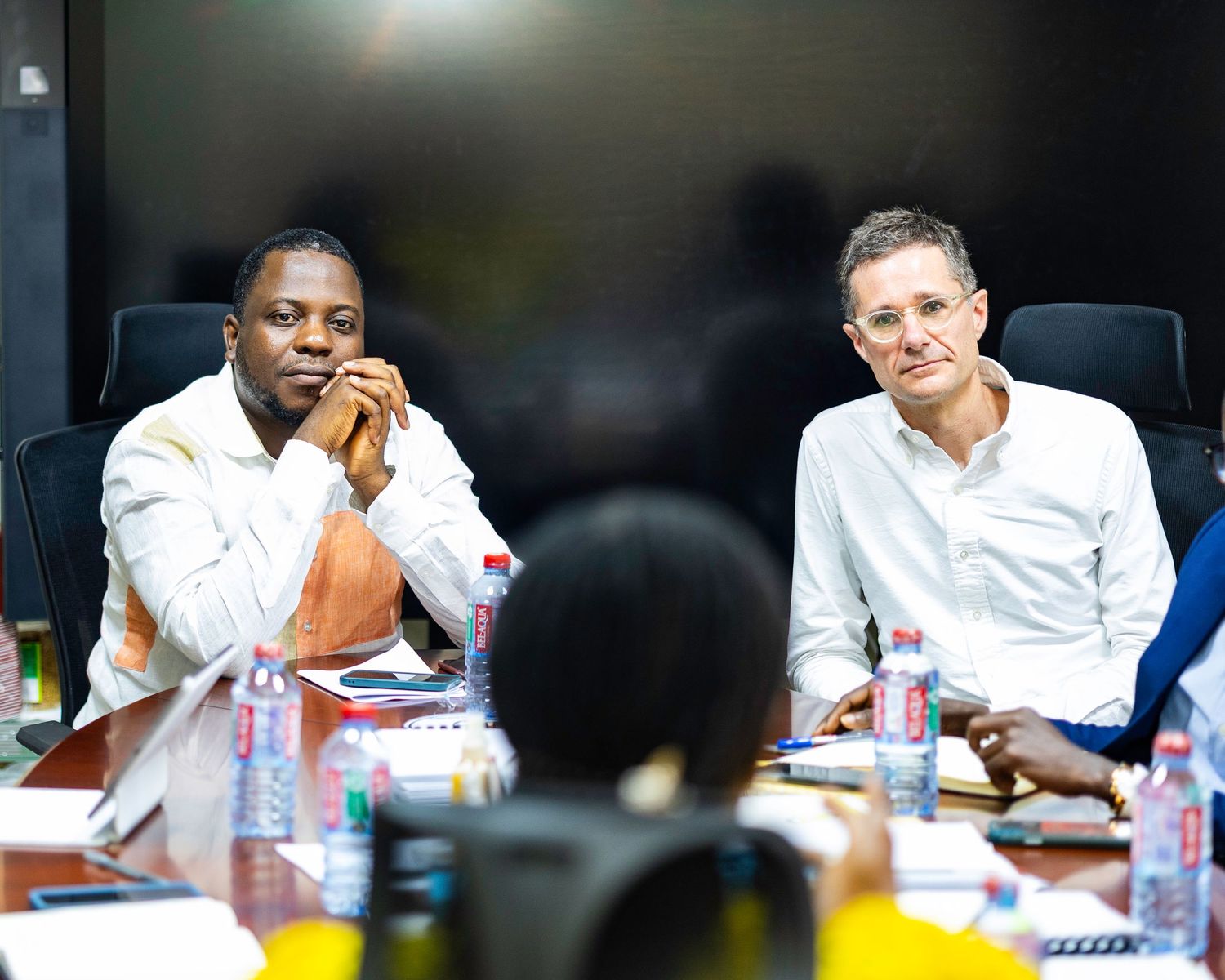 Business professionals engaged in discussion around a conference table during a meeting.