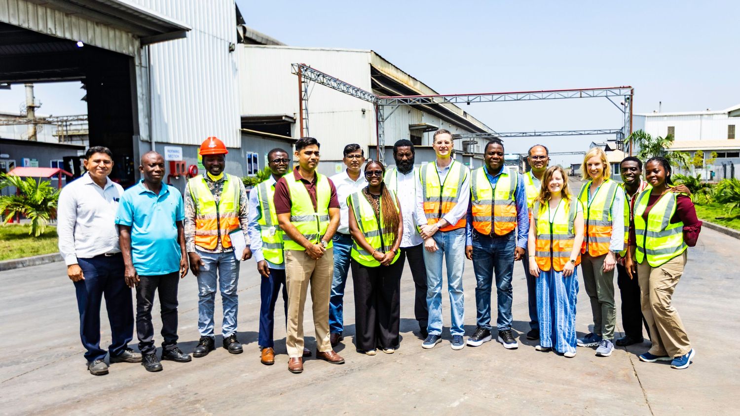 Long line of construction workers in safety gear posing together outdoors.