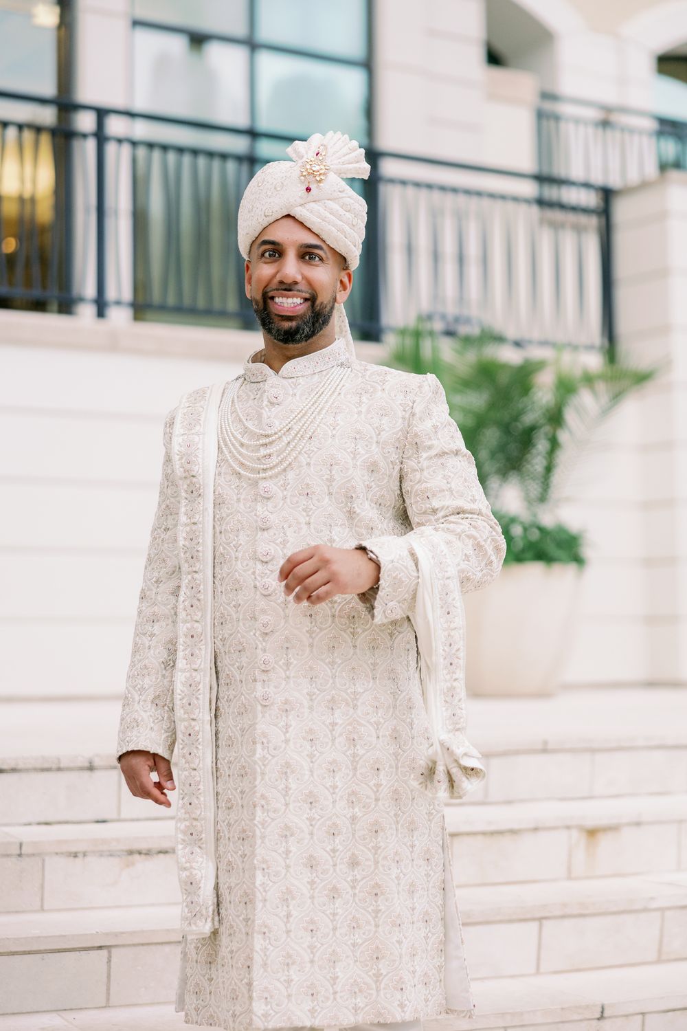A series of photos showing traditional South Asian wedding attire featuring an elegant white and gold embroidered sherwani.