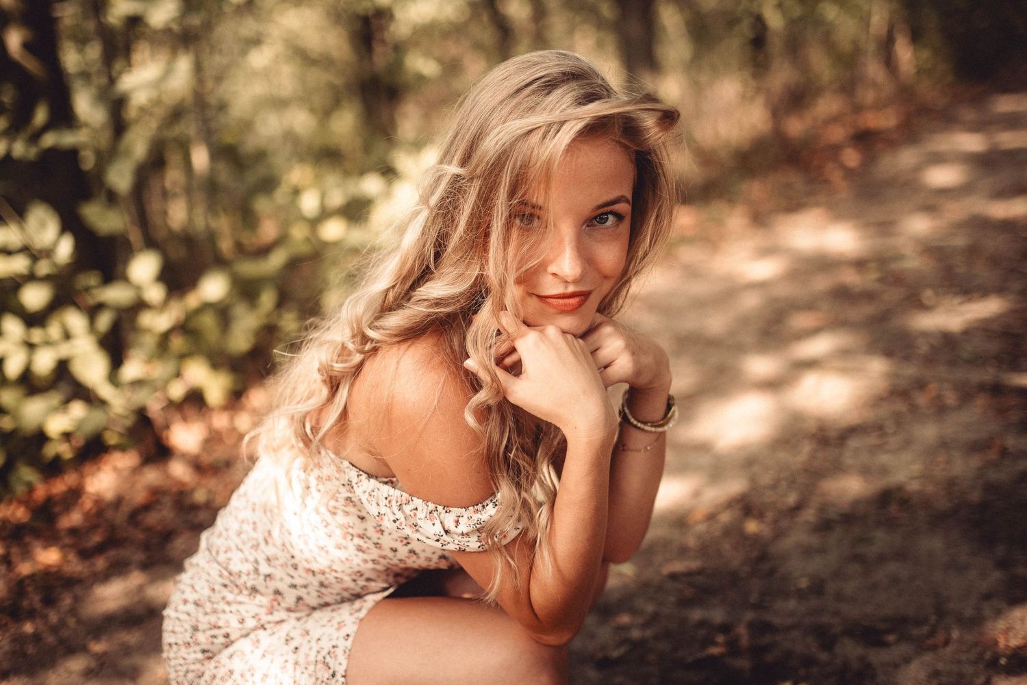 Artistic portrait in dappled forest light wearing a sparkly dress.