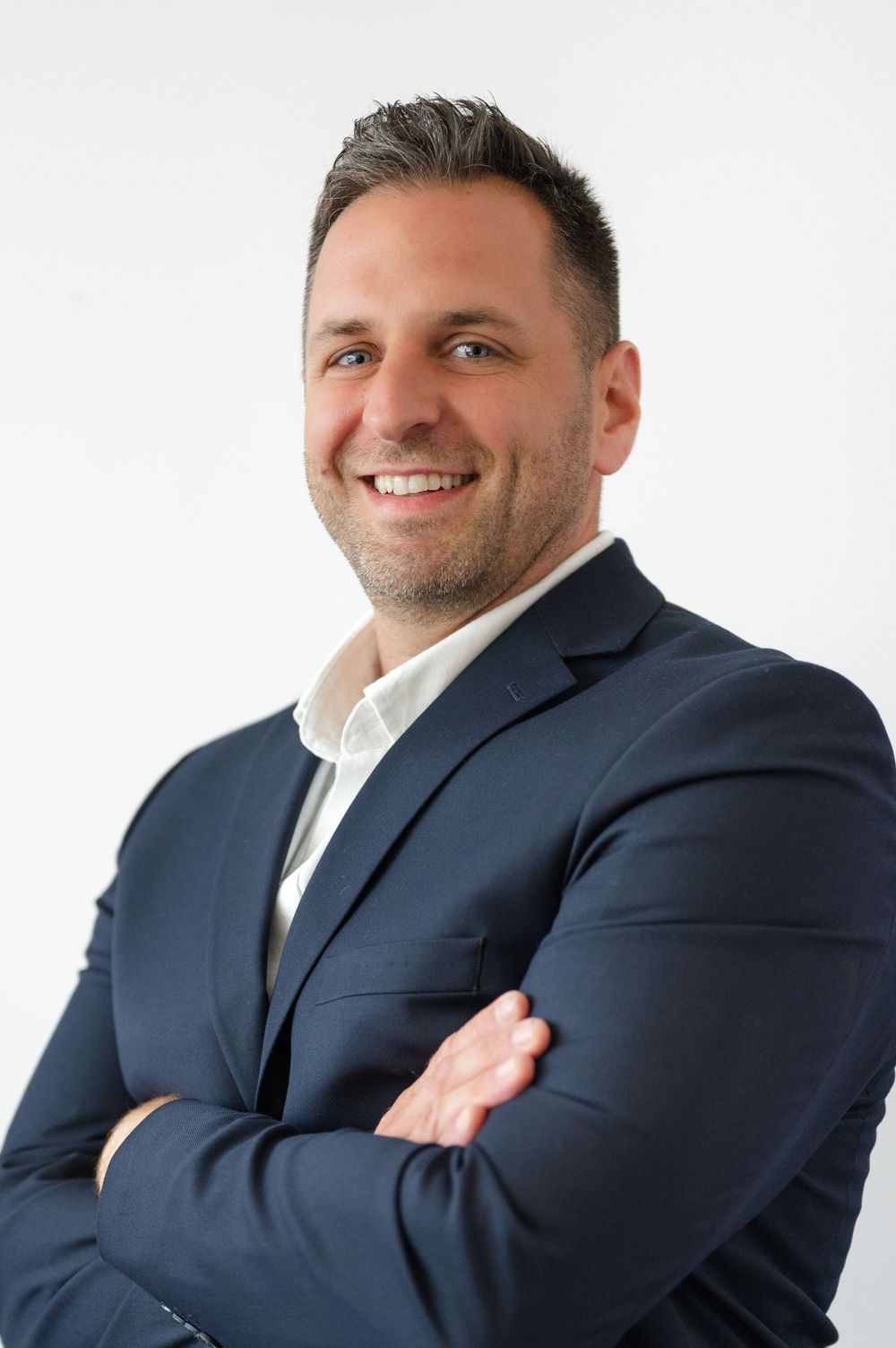 Professional headshots of person in navy suit against white background showing different poses and expressions.