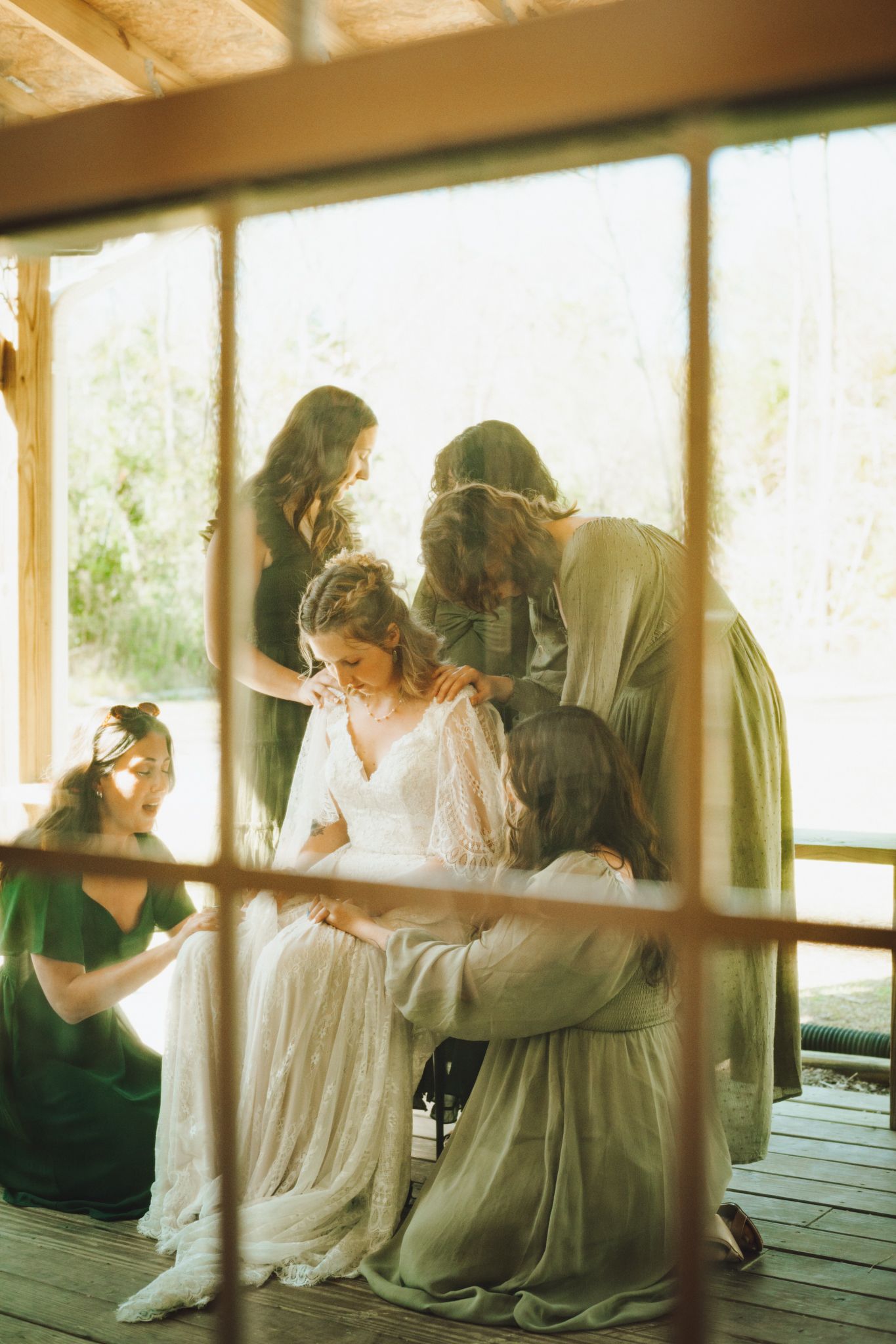 A romantic wedding couple dances and dips outdoors with tall pine trees in the background.