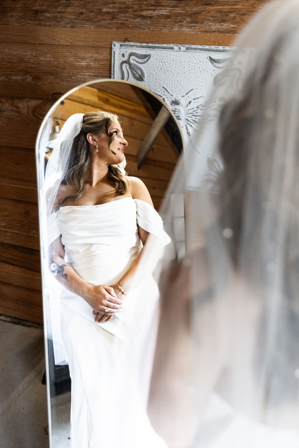 Elegant white wedding dress details captured through a soft focus lens in a rustic setting.