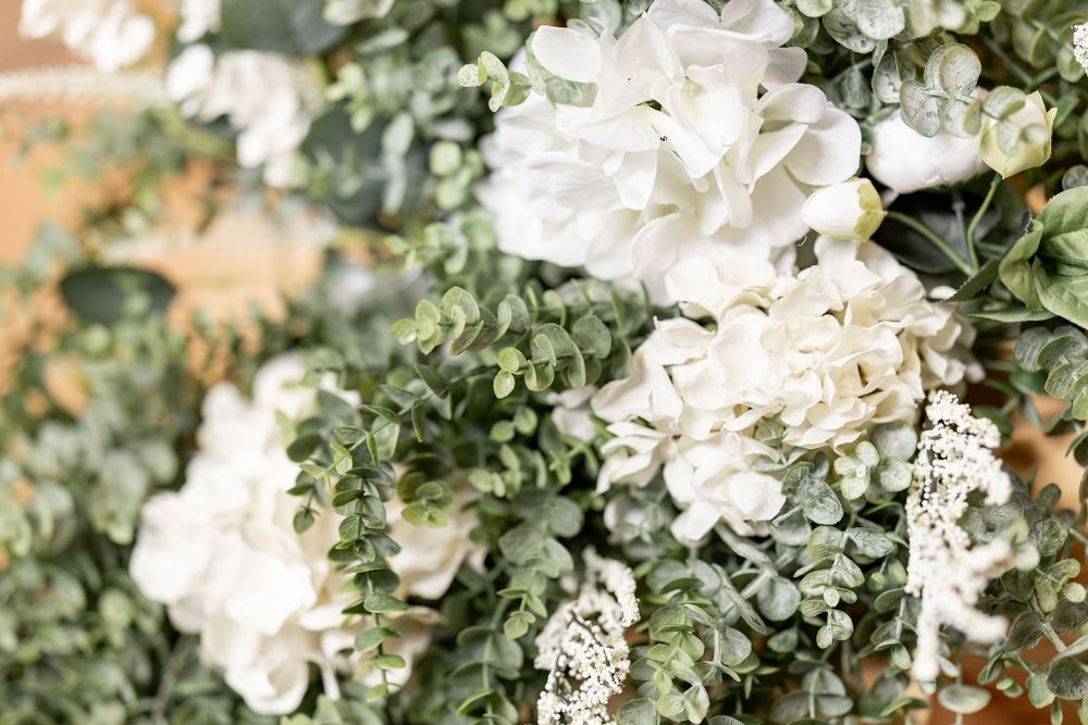 Close-up of lush white floral arrangements with greenery creating a romantic wedding backdrop.