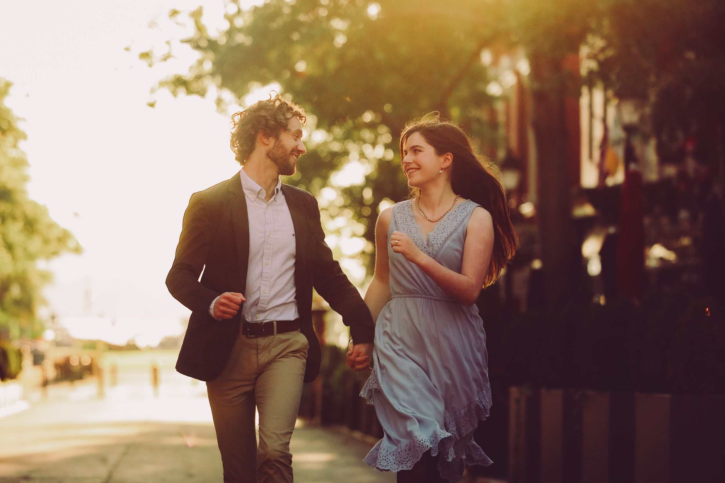 A romantic couple shares tender moments in golden sunlight during a sunset photo session.