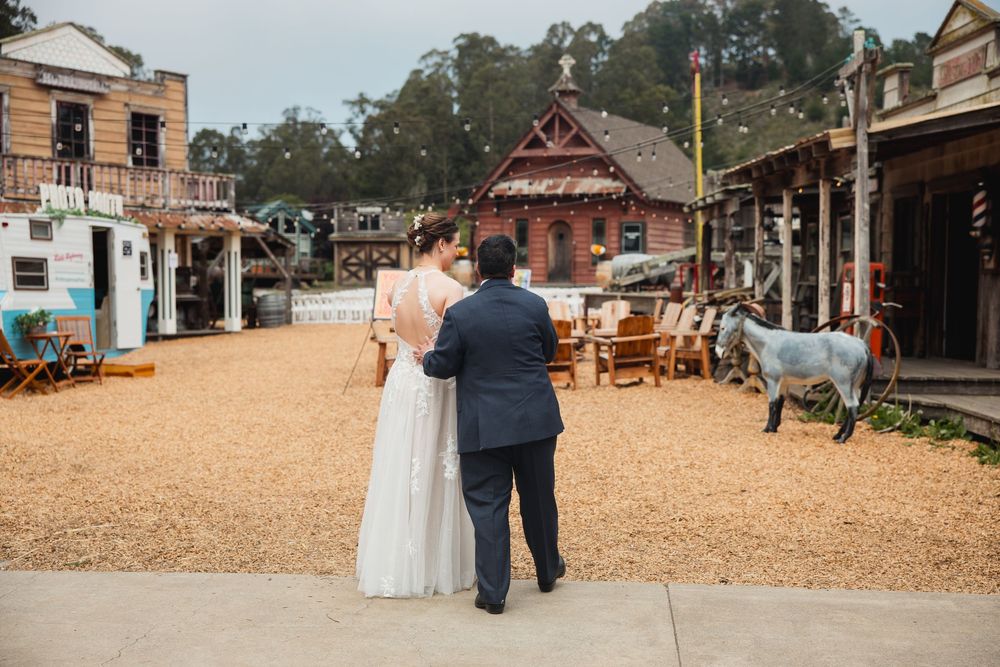 Rustic wooden wedding venue with string lights and chairs set up for an outdoor ceremony.