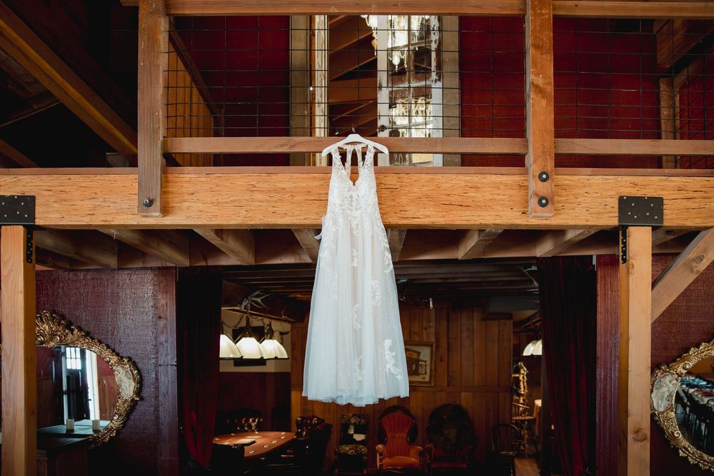 Rustic wooden beams and chandeliers decorate the interior of a barn-style wedding venue.