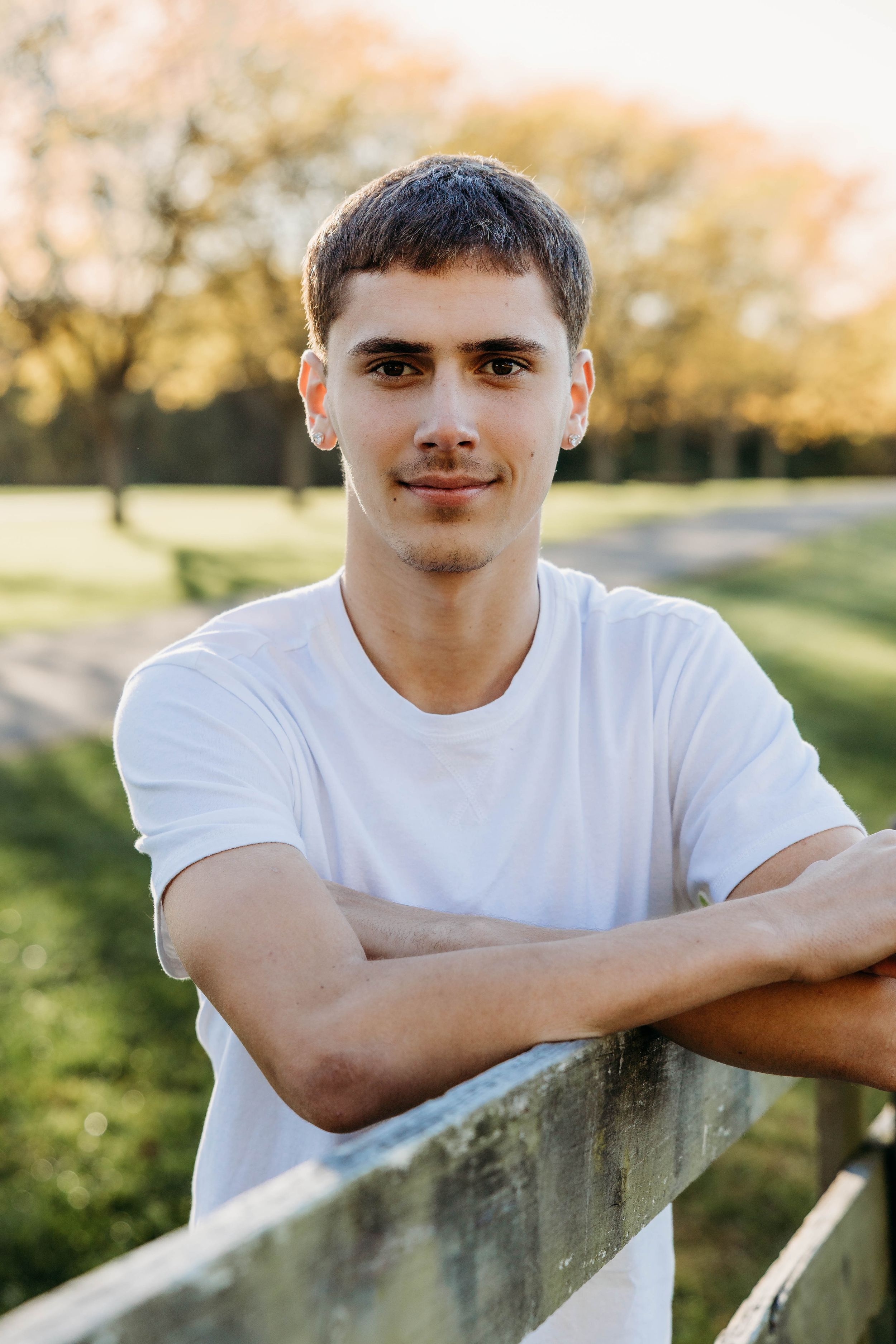 A series of outdoor portrait photographs showing someone in a white t-shirt leaning against a concrete wall at sunset.