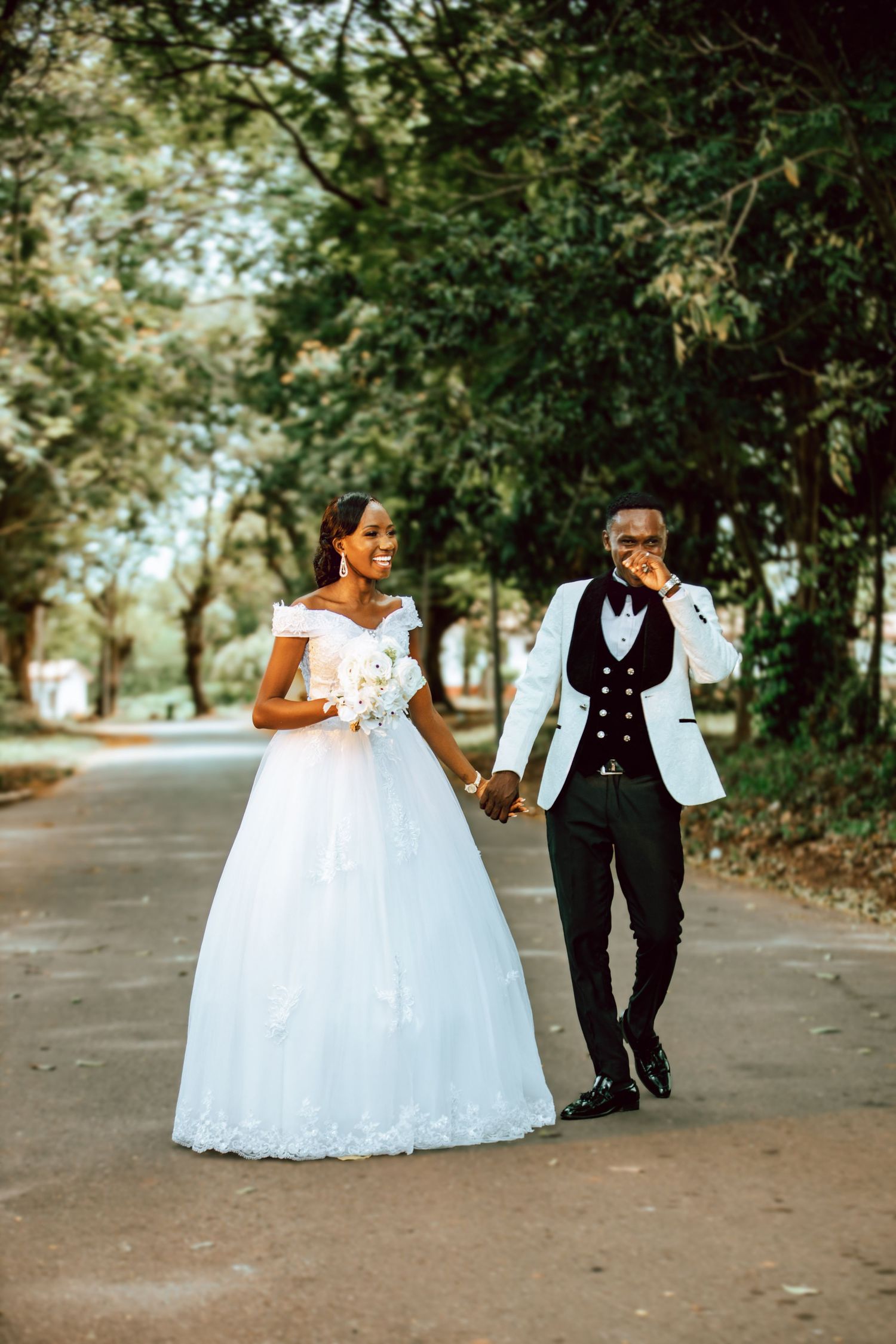 A playful wedding photoshoot sequence on a tree-lined path with bride in flowing white gown.