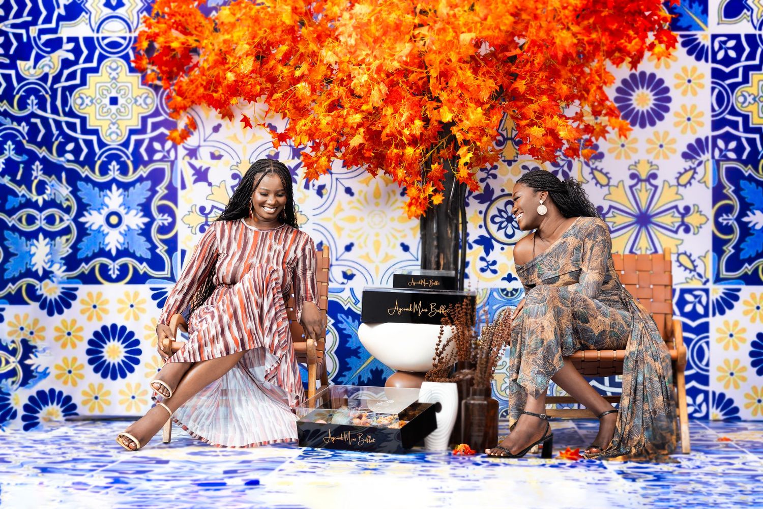 Photo session with autumn orange foliage against blue and white decorative tile wall.