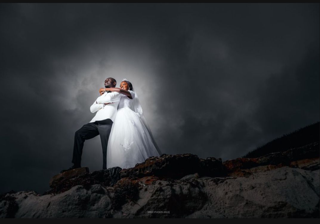 Dramatic black and white wedding photos on a rocky terrain with moody lighting.
