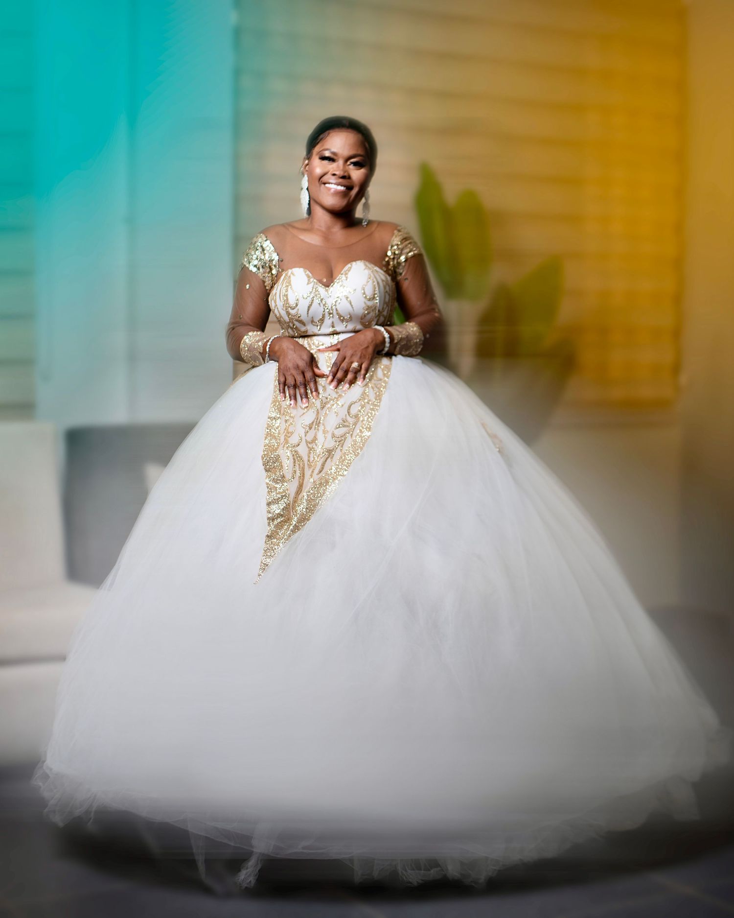 A stunning white ballgown wedding dress with tulle skirt and gold accents captured in an artistic portrait.