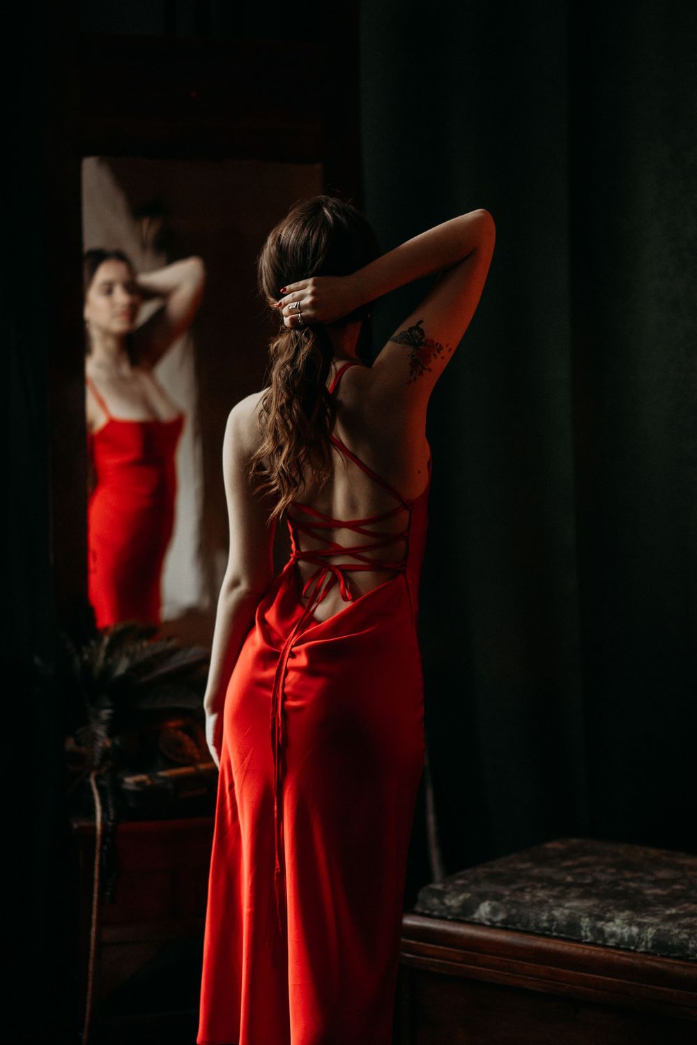 Silhouette of a person in a flowing red dress against a dark background creating a dramatic contrast.